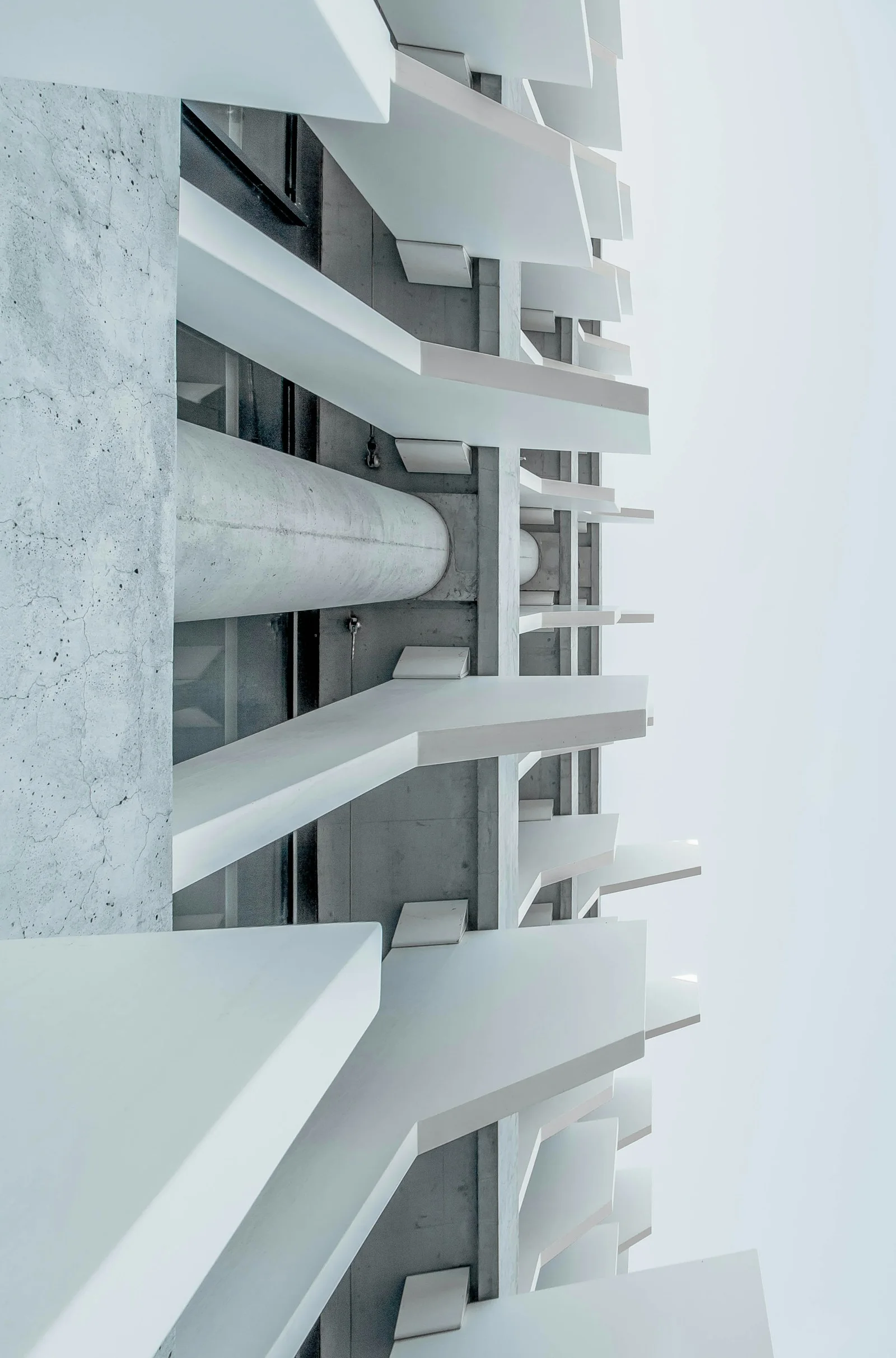 Sculptural white concrete facade with repeating geometric balconies